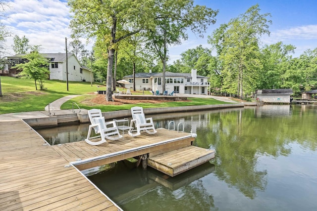 dock area with a lawn and a water view