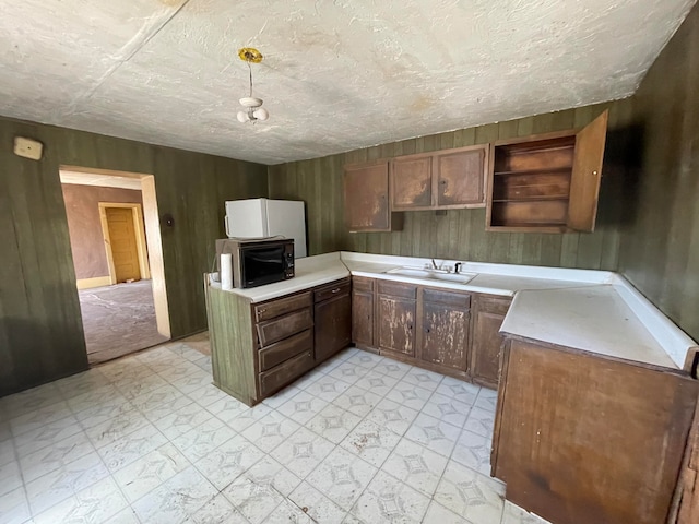 kitchen with light tile floors, a textured ceiling, and sink