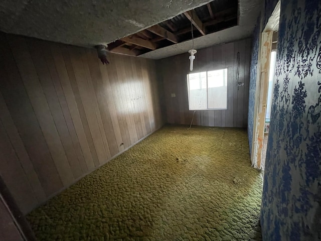 empty room with carpet flooring and wood walls