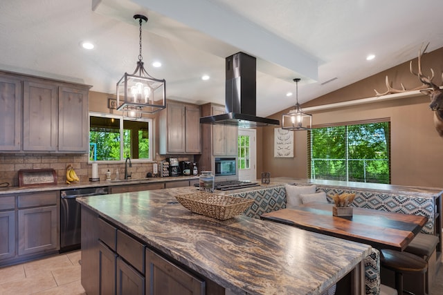 kitchen with dark stone counters, decorative light fixtures, appliances with stainless steel finishes, wall chimney exhaust hood, and backsplash