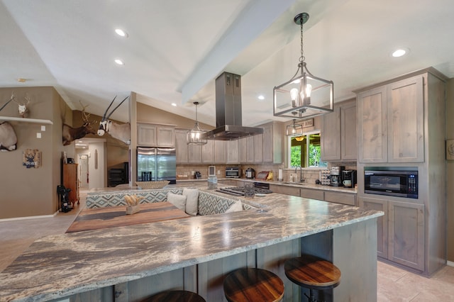 kitchen with hanging light fixtures, a breakfast bar area, island range hood, stainless steel refrigerator with ice dispenser, and black microwave