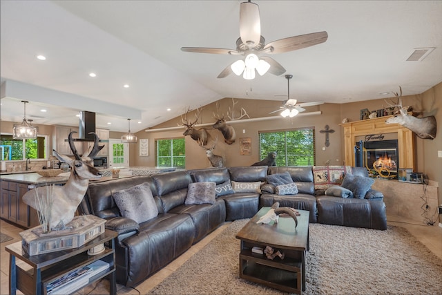 living room featuring a wealth of natural light, light tile floors, and ceiling fan with notable chandelier