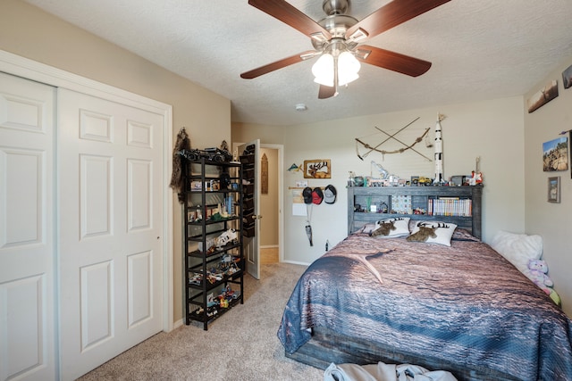 bedroom featuring light carpet, a textured ceiling, a closet, and ceiling fan