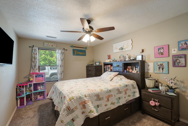 bedroom featuring a textured ceiling, ceiling fan, and dark carpet