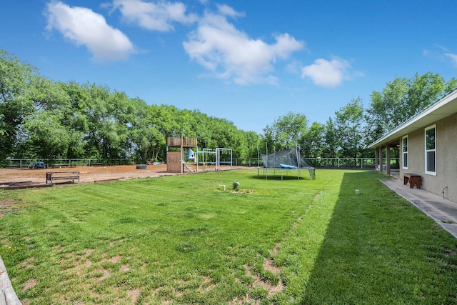 view of yard featuring a playground and a trampoline