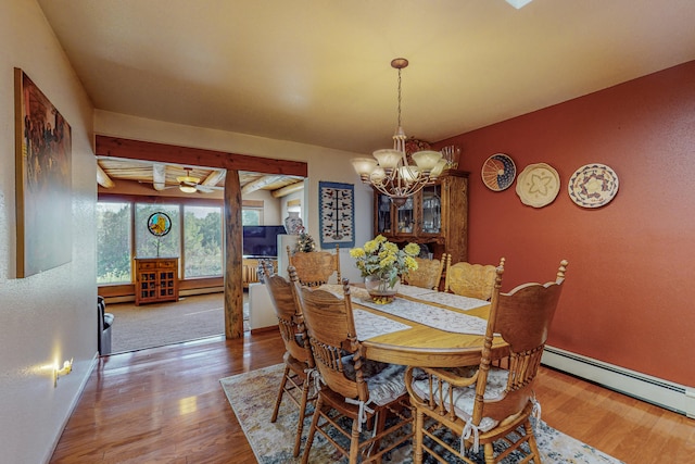 dining area with a baseboard radiator, light hardwood / wood-style flooring, and an inviting chandelier