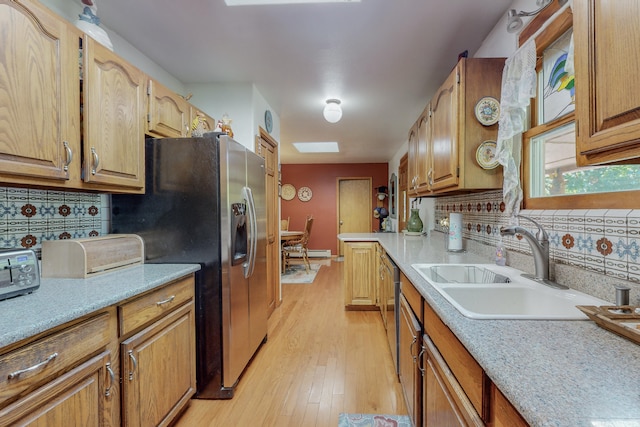 kitchen featuring stainless steel fridge, tasteful backsplash, light hardwood / wood-style floors, and sink