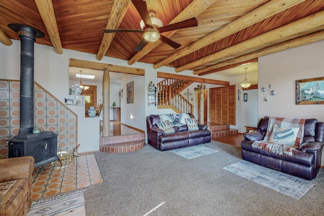 carpeted living room featuring ceiling fan, wooden ceiling, a wood stove, and beam ceiling