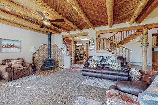 carpeted living room with ceiling fan, a wood stove, beam ceiling, and wood ceiling