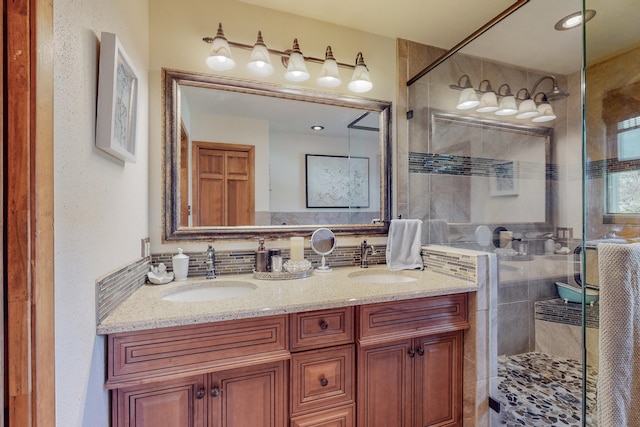 bathroom with double sink vanity, tasteful backsplash, tile walls, and a shower with shower door