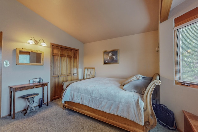 carpeted bedroom with a closet and lofted ceiling