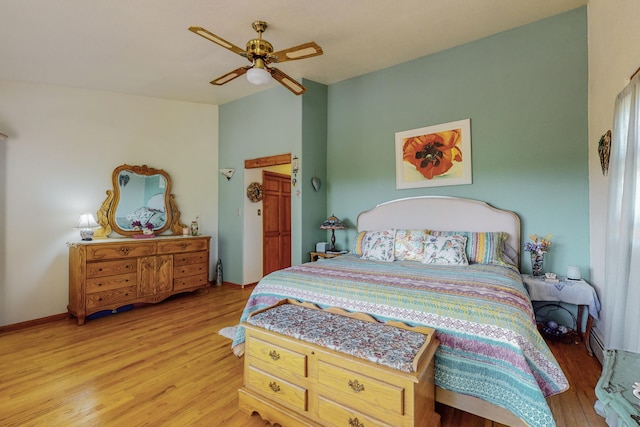 bedroom with ceiling fan, light hardwood / wood-style flooring, and a baseboard heating unit