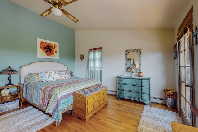 bedroom featuring vaulted ceiling, ceiling fan, light hardwood / wood-style floors, and a baseboard radiator