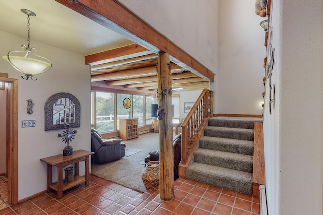 stairs with beam ceiling and dark tile flooring