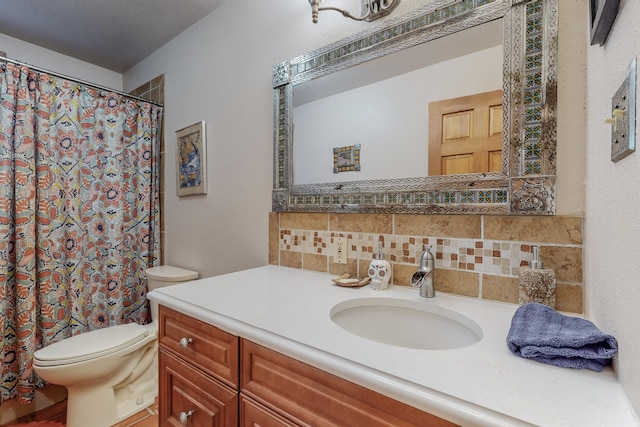 bathroom featuring toilet, vanity, and tasteful backsplash