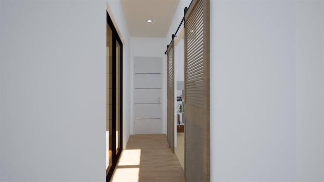 hall featuring a barn door and light hardwood / wood-style flooring