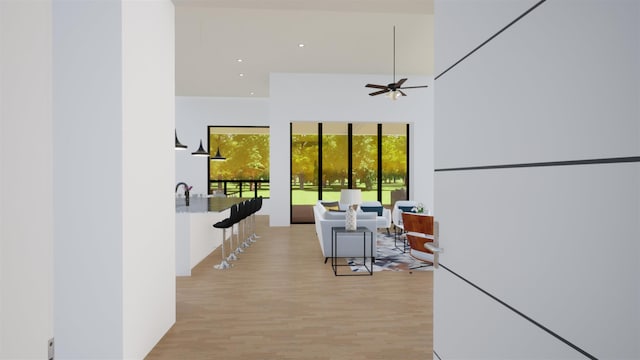 hallway with a towering ceiling and light hardwood / wood-style floors