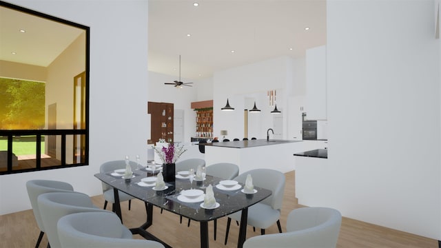 dining space with sink, ceiling fan, and light wood-type flooring