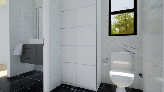 bathroom featuring tile walls and toilet