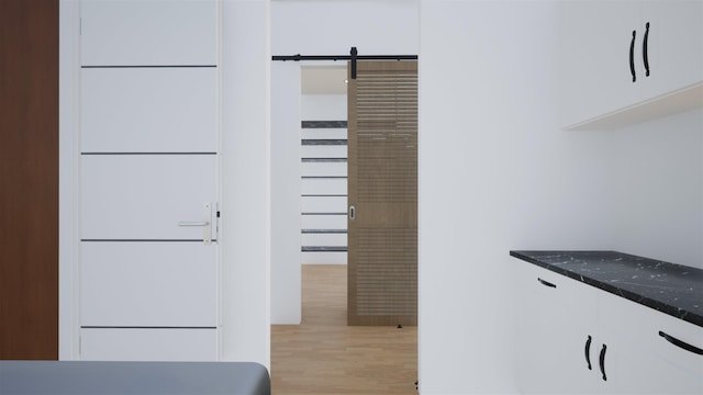 interior space with dark stone countertops, light hardwood / wood-style floors, and white cabinets