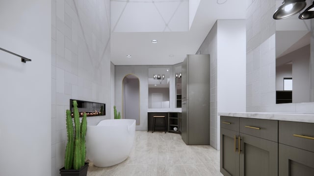 bathroom featuring a large fireplace, tile walls, vanity, a bath, and tile patterned floors