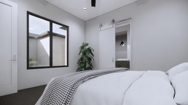 bedroom with wood-type flooring, a barn door, and ceiling fan