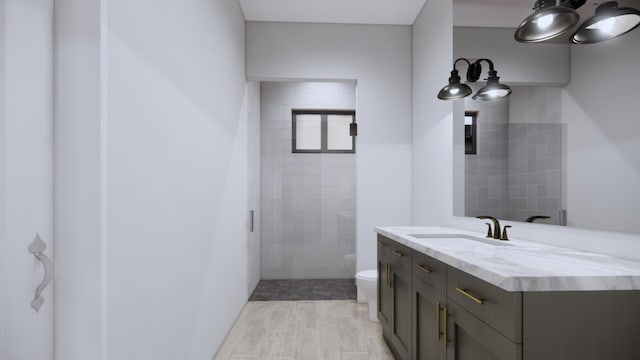 bathroom featuring vanity, toilet, and a tile shower