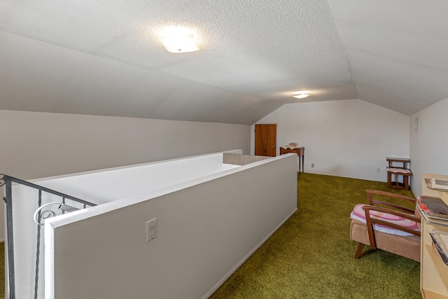 additional living space featuring a textured ceiling, dark carpet, and vaulted ceiling