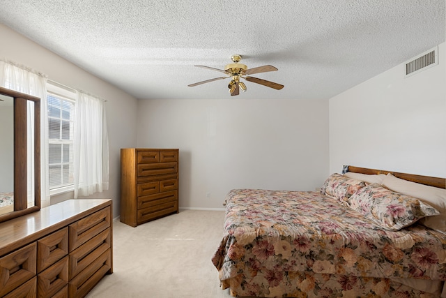 carpeted bedroom with a textured ceiling and ceiling fan