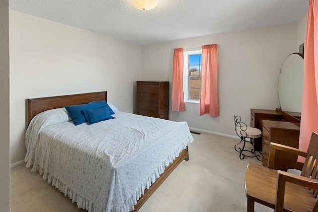 bedroom featuring a textured ceiling and light carpet