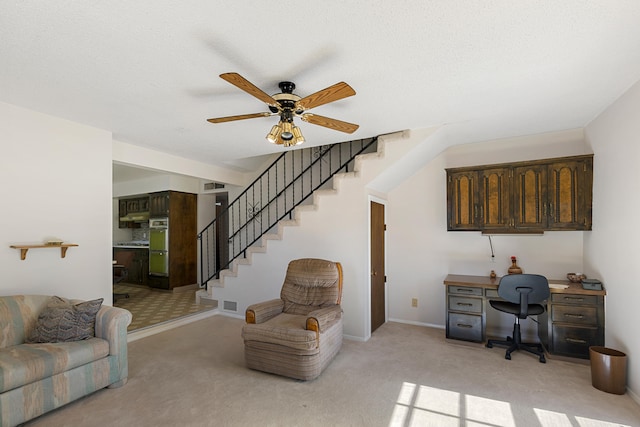 carpeted office space with ceiling fan