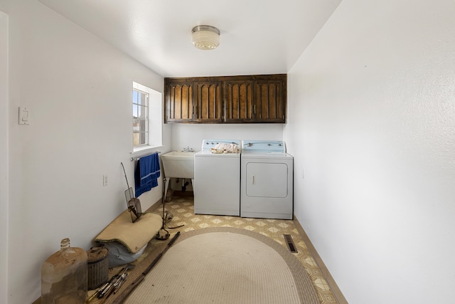 washroom with washer and dryer, light colored carpet, and cabinets