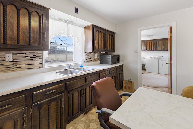 kitchen featuring light tile floors, separate washer and dryer, tasteful backsplash, dark brown cabinets, and sink