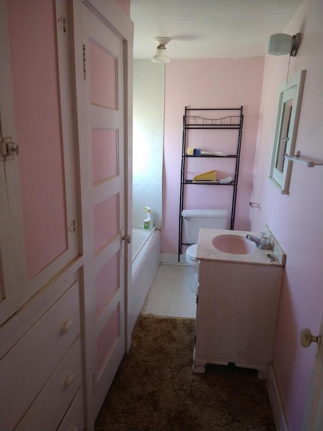 bathroom with tile flooring, large vanity, and toilet