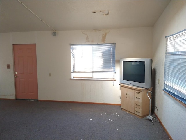 spare room featuring dark carpet