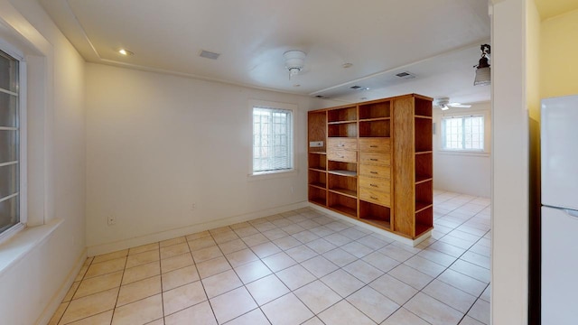 tiled spare room with ceiling fan