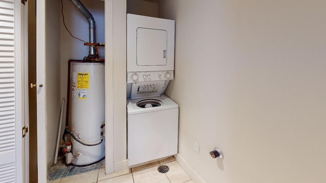 laundry room featuring gas water heater, stacked washing maching and dryer, and light tile flooring