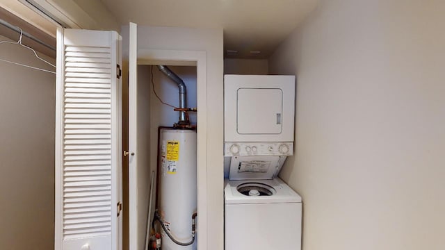 clothes washing area featuring stacked washer and clothes dryer and gas water heater