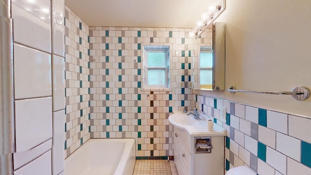 bathroom with vanity, tile walls, tile floors, tiled shower / bath, and tasteful backsplash