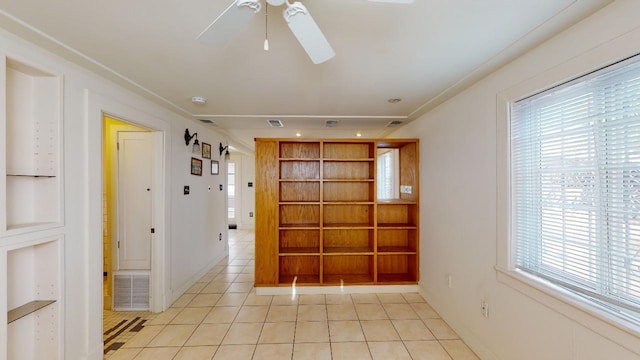 hall with a wealth of natural light and light tile floors