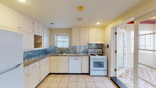 kitchen with light tile flooring, tasteful backsplash, white appliances, sink, and white cabinetry