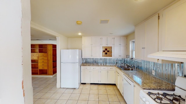 kitchen featuring white cabinets, light tile floors, dark stone countertops, backsplash, and white appliances