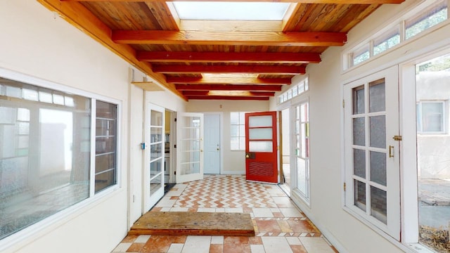 unfurnished sunroom with french doors, beam ceiling, and wooden ceiling