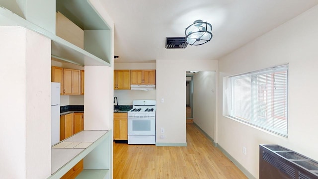 kitchen featuring white appliances and light wood-type flooring