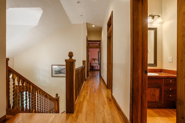 hall featuring light hardwood / wood-style flooring and vaulted ceiling