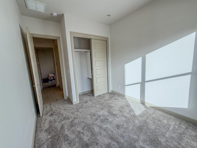 unfurnished bedroom with light carpet and a closet