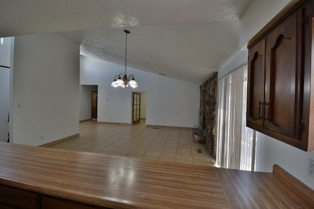 interior space featuring a notable chandelier, a textured ceiling, light hardwood / wood-style flooring, and vaulted ceiling