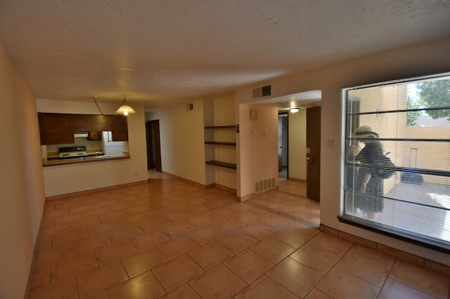 unfurnished living room featuring a textured ceiling and light tile patterned floors