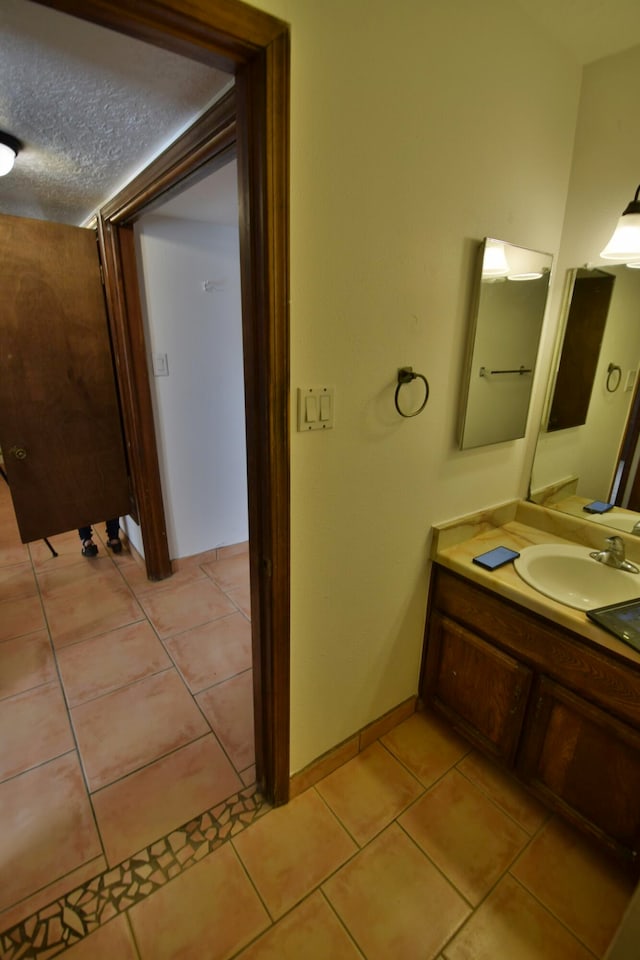 bathroom featuring a textured ceiling, tile patterned flooring, and vanity