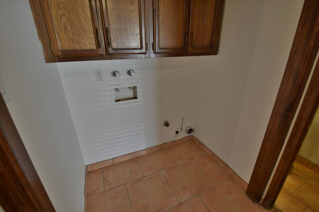 laundry room featuring hookup for a washing machine, light tile patterned floors, electric dryer hookup, cabinets, and gas dryer hookup